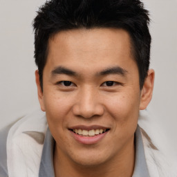 Joyful asian young-adult male with short  brown hair and brown eyes