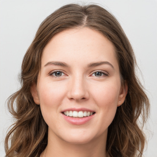 Joyful white young-adult female with long  brown hair and grey eyes