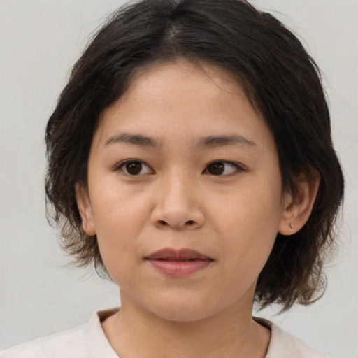 Joyful asian child female with medium  brown hair and brown eyes