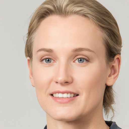 Joyful white young-adult female with medium  brown hair and blue eyes