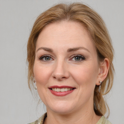 Joyful white adult female with medium  brown hair and blue eyes