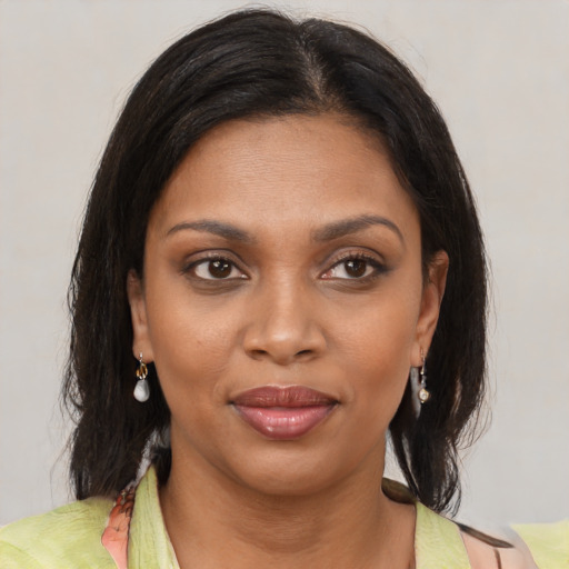 Joyful black young-adult female with medium  brown hair and brown eyes