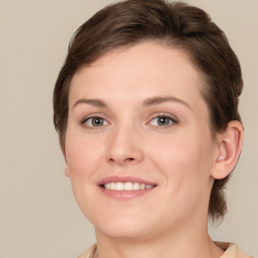 Joyful white young-adult female with medium  brown hair and grey eyes