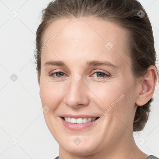 Joyful white young-adult female with medium  brown hair and grey eyes