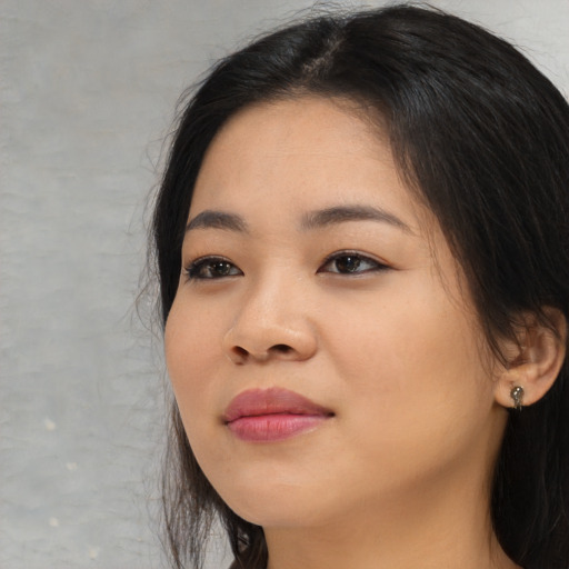 Joyful asian young-adult female with long  black hair and brown eyes