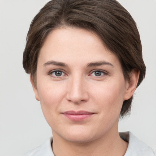 Joyful white young-adult female with short  brown hair and grey eyes