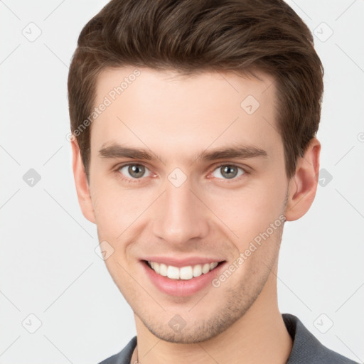 Joyful white young-adult male with short  brown hair and grey eyes