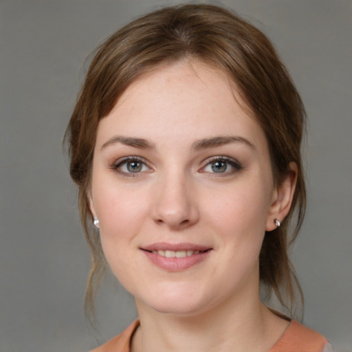 Joyful white young-adult female with medium  brown hair and grey eyes