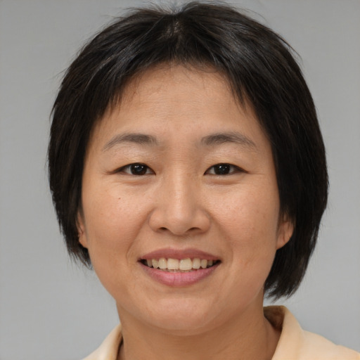 Joyful asian adult female with medium  brown hair and brown eyes