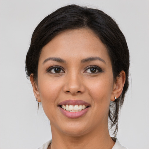 Joyful latino young-adult female with medium  brown hair and brown eyes