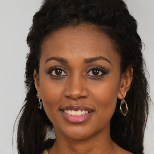 Joyful black young-adult female with long  black hair and brown eyes