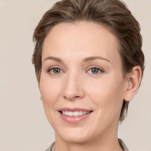 Joyful white young-adult female with short  brown hair and grey eyes