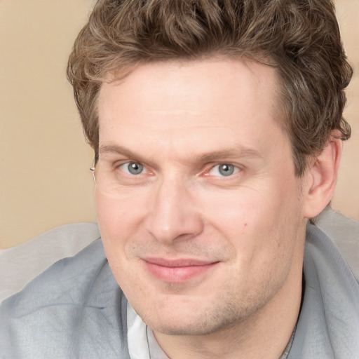 Joyful white adult male with short  brown hair and grey eyes