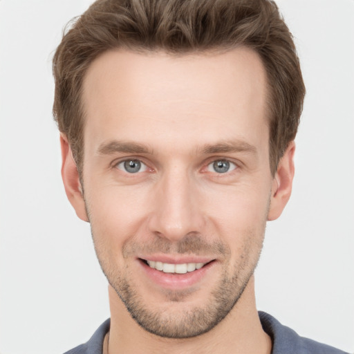 Joyful white young-adult male with short  brown hair and grey eyes