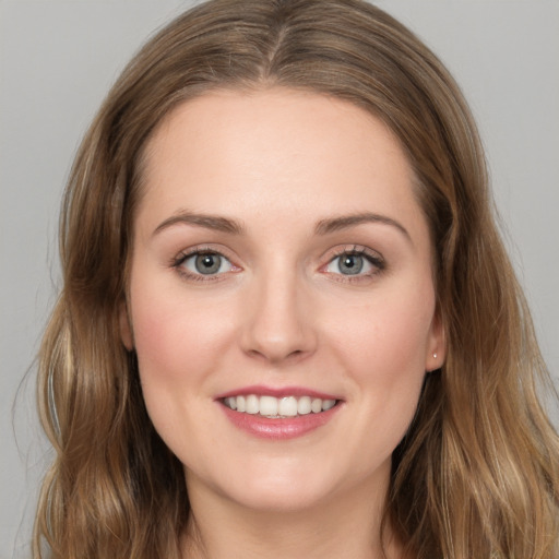 Joyful white young-adult female with long  brown hair and blue eyes