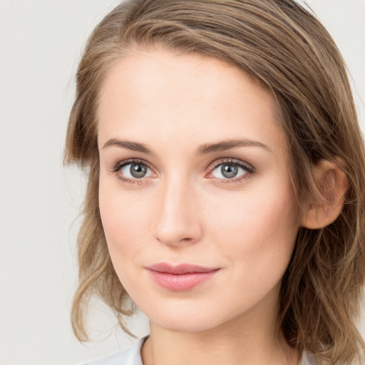 Joyful white young-adult female with medium  brown hair and blue eyes