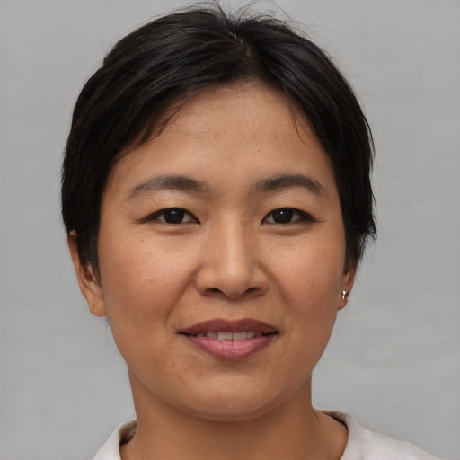 Joyful asian young-adult female with short  brown hair and brown eyes