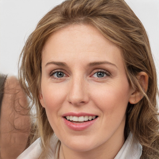 Joyful white young-adult female with medium  brown hair and blue eyes