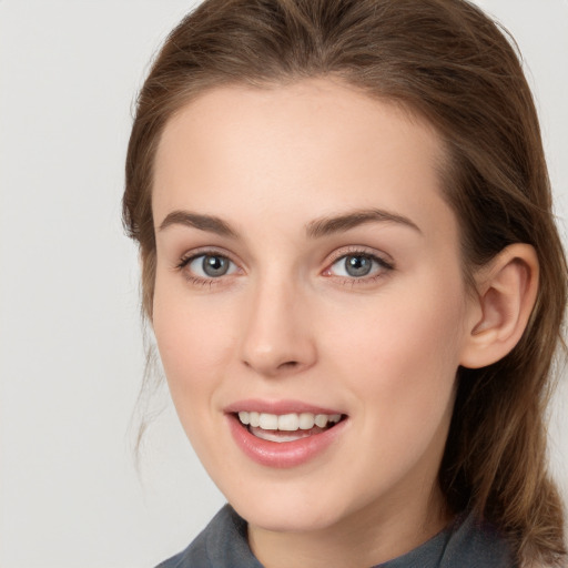 Joyful white young-adult female with medium  brown hair and grey eyes