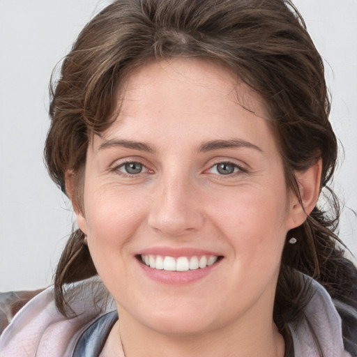 Joyful white young-adult female with medium  brown hair and grey eyes