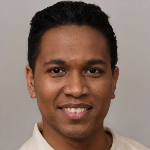 Joyful black young-adult male with short  black hair and brown eyes