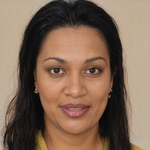 Joyful black adult female with long  brown hair and brown eyes