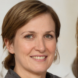 Joyful white adult female with medium  brown hair and brown eyes