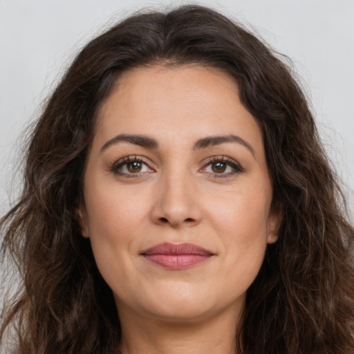 Joyful white adult female with long  brown hair and brown eyes