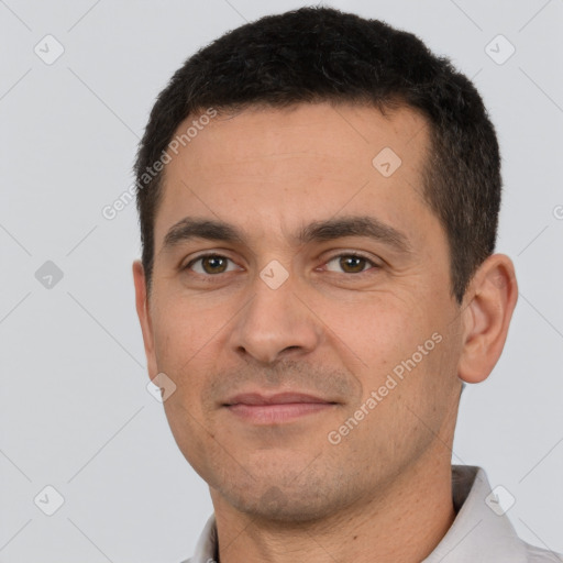 Joyful white young-adult male with short  black hair and brown eyes