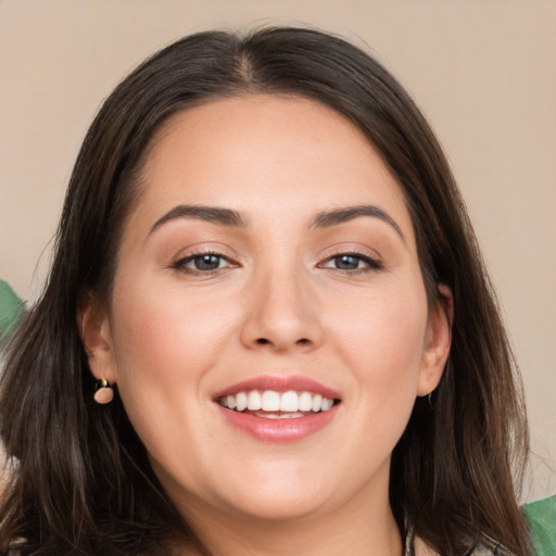 Joyful white young-adult female with long  brown hair and brown eyes