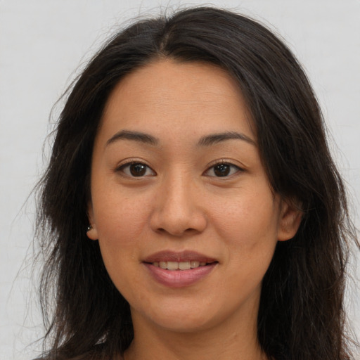 Joyful asian adult female with long  brown hair and brown eyes