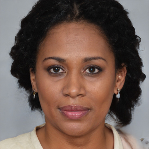 Joyful black adult female with medium  brown hair and brown eyes