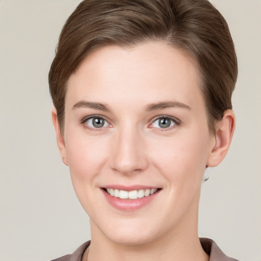 Joyful white young-adult female with short  brown hair and grey eyes