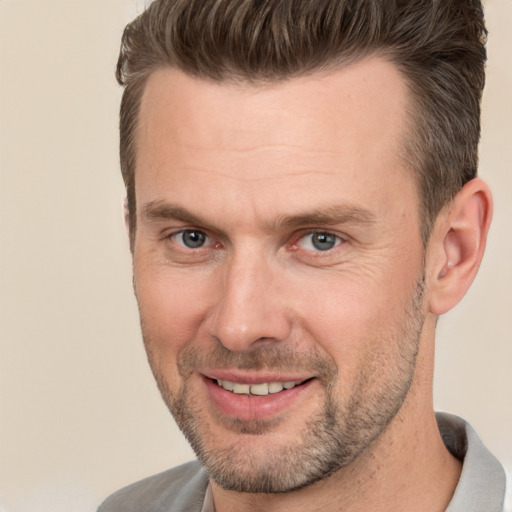 Joyful white adult male with short  brown hair and brown eyes