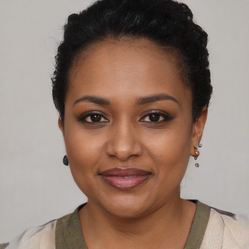 Joyful black young-adult female with short  black hair and brown eyes