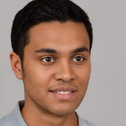 Joyful latino young-adult male with short  brown hair and brown eyes