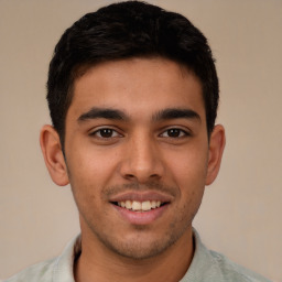 Joyful latino young-adult male with short  brown hair and brown eyes