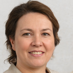 Joyful white adult female with medium  brown hair and grey eyes