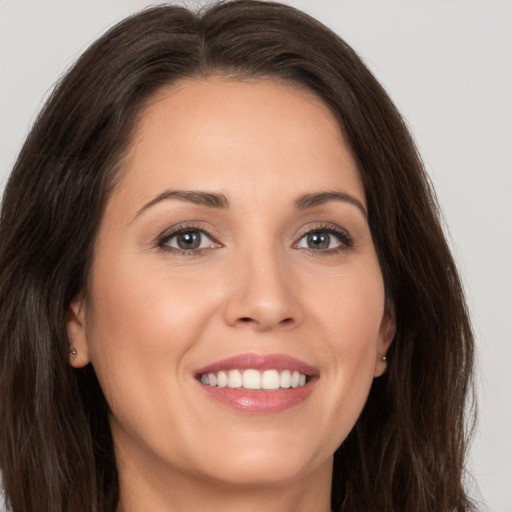 Joyful white young-adult female with long  brown hair and brown eyes