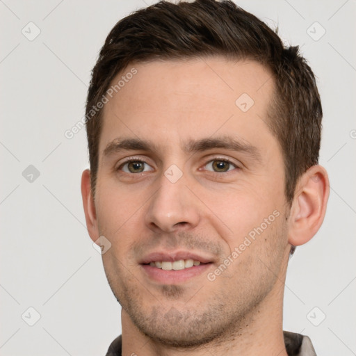 Joyful white young-adult male with short  brown hair and grey eyes