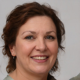 Joyful white adult female with medium  brown hair and blue eyes