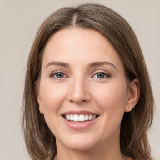 Joyful white young-adult female with medium  brown hair and grey eyes