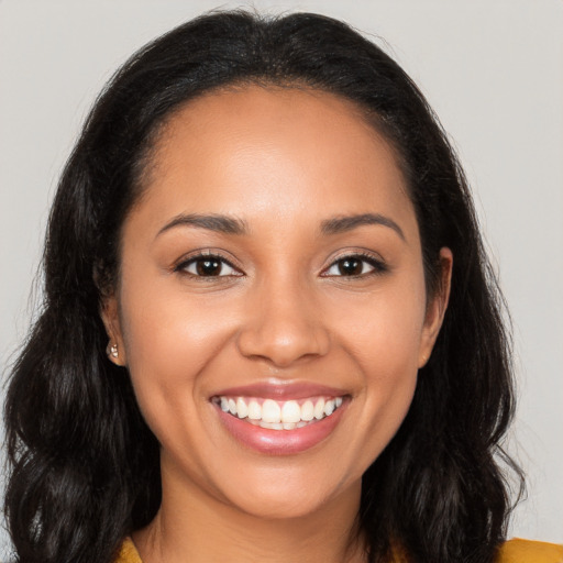 Joyful latino young-adult female with long  brown hair and brown eyes