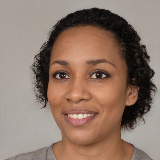 Joyful black young-adult female with medium  black hair and brown eyes