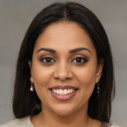 Joyful latino young-adult female with medium  brown hair and brown eyes