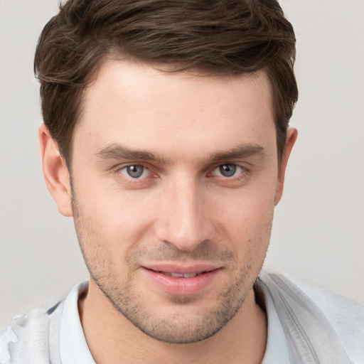 Joyful white young-adult male with short  brown hair and grey eyes