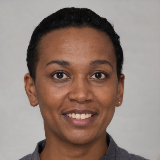 Joyful black adult female with short  black hair and brown eyes