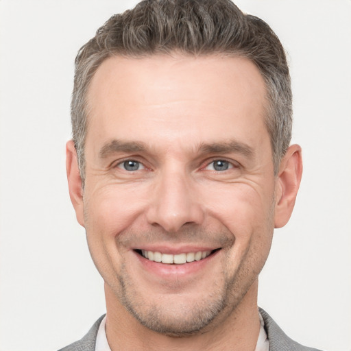 Joyful white adult male with short  brown hair and grey eyes