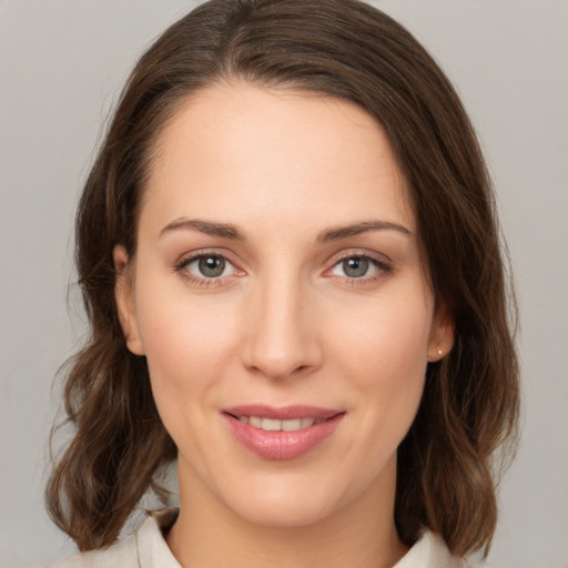 Joyful white young-adult female with medium  brown hair and green eyes