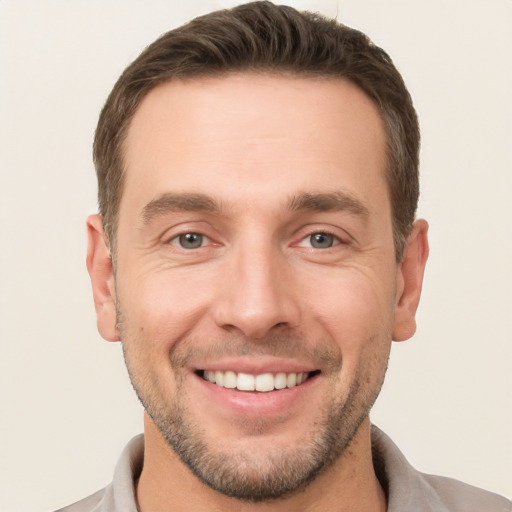 Joyful white young-adult male with short  brown hair and brown eyes